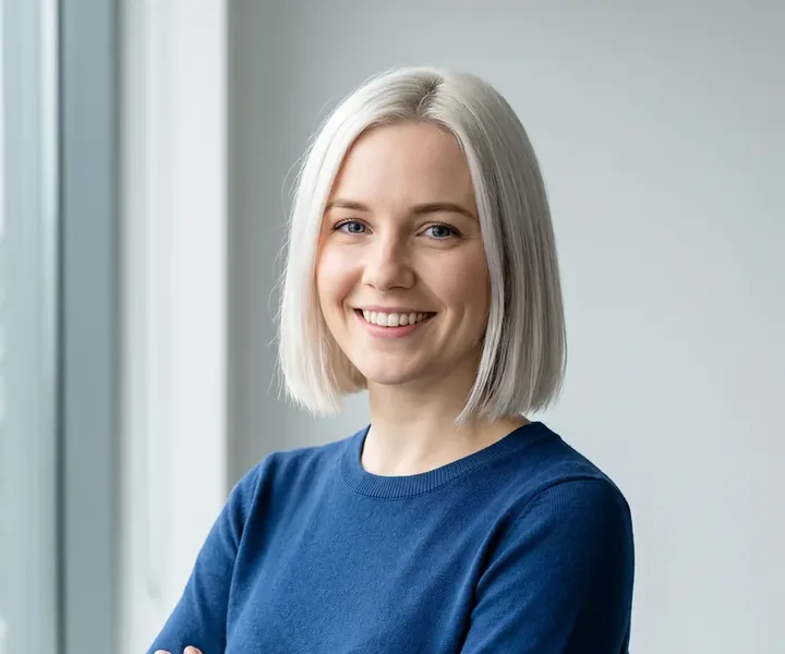 Office manager Liisi Pallas, with chin-length platinum blonde hair and a blue sweater, smiles in front of the window, the monthly bill arrives as an e-invoice in the client's accounting program.