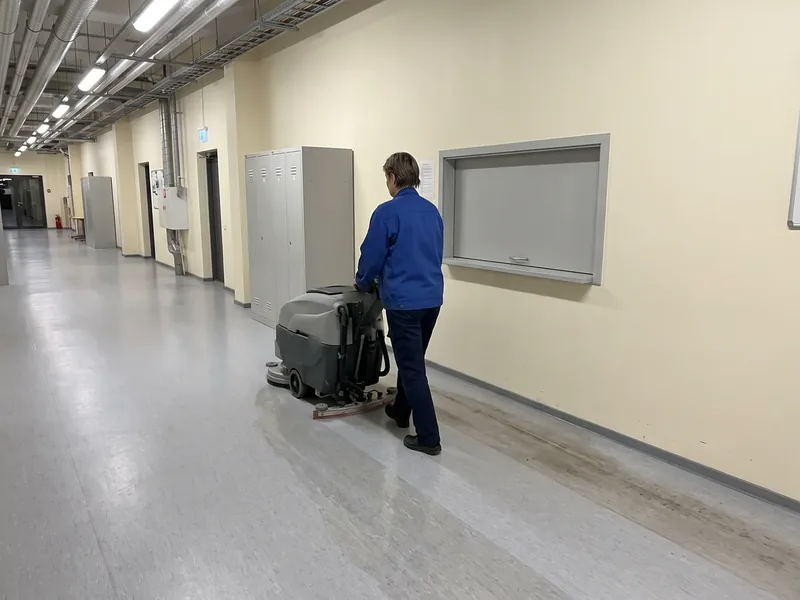 Operaator sinises tööjakis juhib pesuimurit logistikaterminali kontoritiiva pikal helehallil PVC-koridoril, seina ääres on tumedam käiguriba, pesuimuri aku laetakse enne õhtust väljasõitu Ülemiste laos täis.