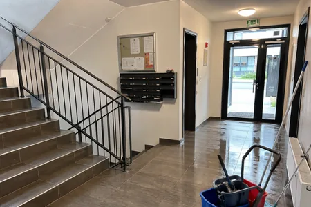 Kortermaja trepikoja esik postkastide, klaasukse ja mopikäruga, märkuse saab saata ka visiidilehe QR-koodi kaudu.